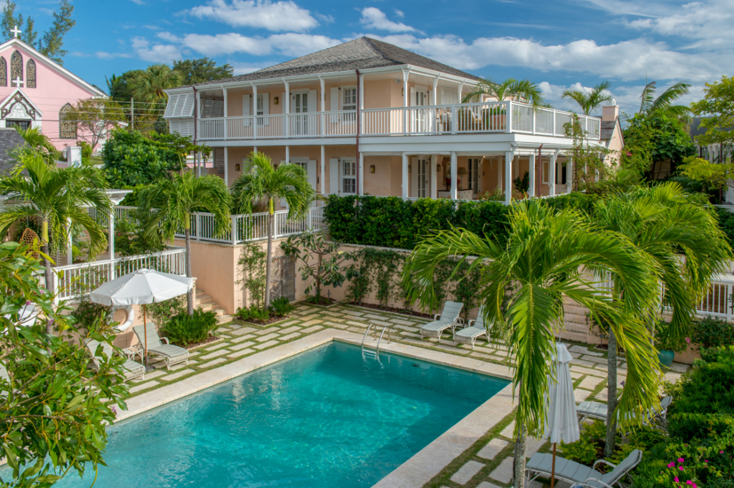 There is a large pink lodge, with a pool in the center of a variety of buildings. The lodge is surro