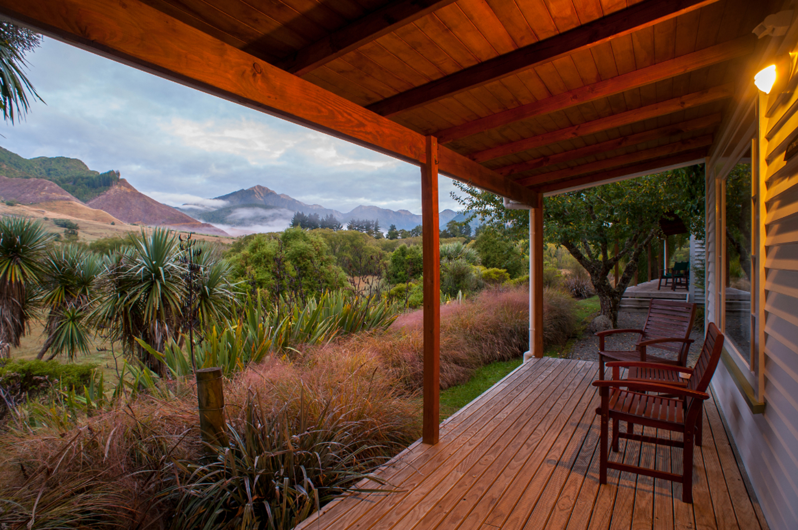 A summer evening is seen from the porch at Owen River Lodge. You can see the porch with chairs with 