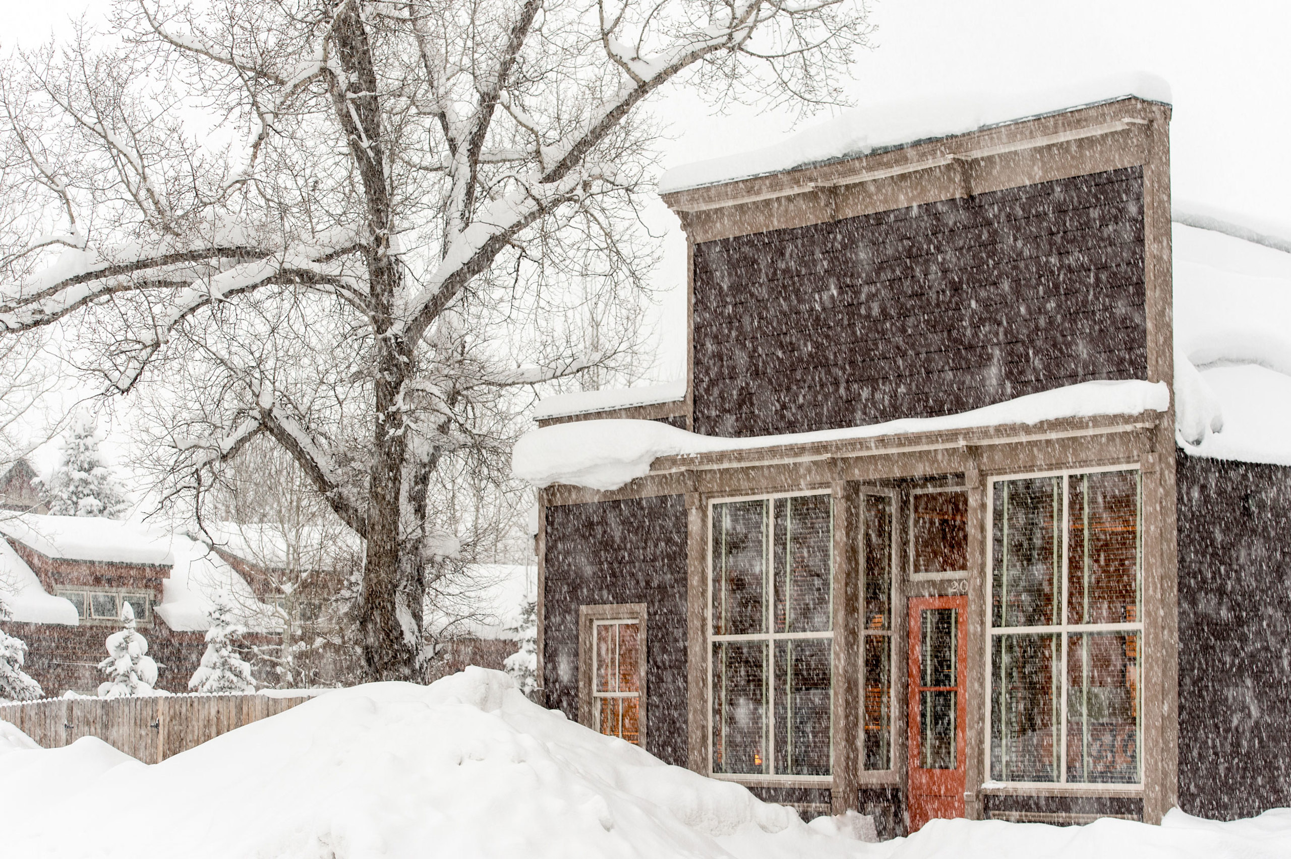 Exterior of a snow covered lodge, the building is a historic western building and there is snow in t