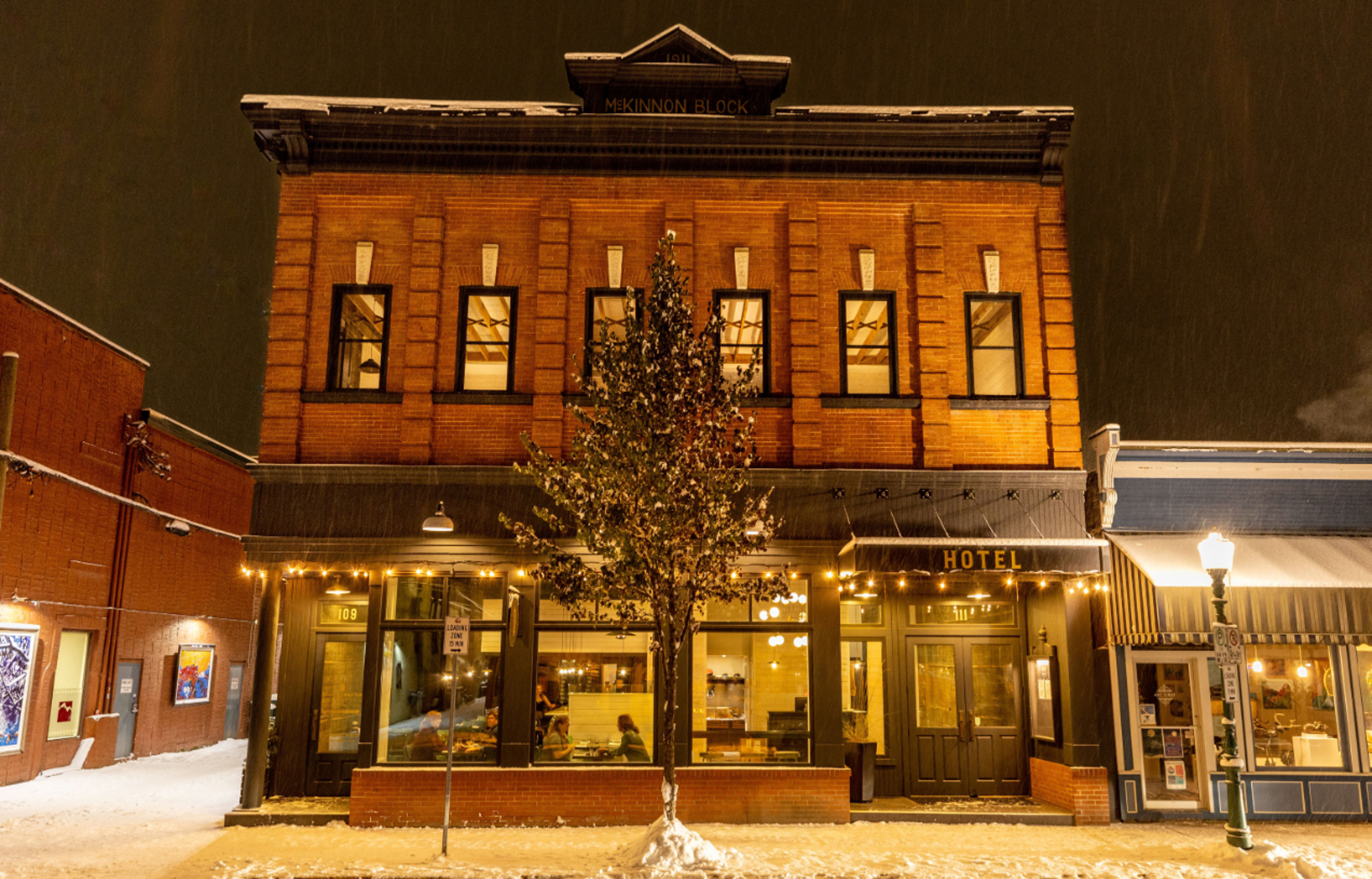 A snow covered brike building is seen in historic downtown Revelstoke on a winter night. A warm glow